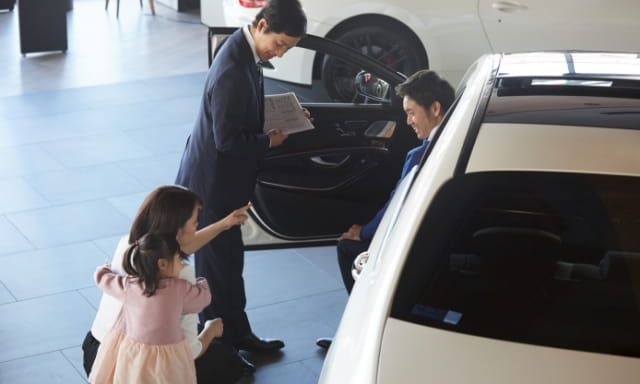 ディーラーで車を確認する家族